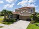 Beautiful two-story home featuring a red tile roof, attached two car garage, and well manicured lawn at 7618 Oakmoss Loop, Davenport, FL 33837