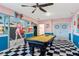 Spacious game room with a pool table, retro diner mural, and black and white checkered floors at 7618 Oakmoss Loop, Davenport, FL 33837