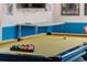 Close-up of a billiards table in a retro-themed game room with colorful balls and a yellow felt surface at 7618 Oakmoss Loop, Davenport, FL 33837