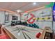 Enjoy this awesome game room with air hockey, wall art, and comfortable seating at 7618 Oakmoss Loop, Davenport, FL 33837