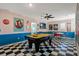 Retro game room with checkered floors, pool table, dining set, and nostalgic diner-themed decor at 7618 Oakmoss Loop, Davenport, FL 33837