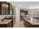 Kitchen features dark cabinets, stainless appliances, granite counters and eat-in space at 7618 Oakmoss Loop, Davenport, FL 33837