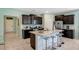 Bright eat-in kitchen featuring dark cabinets, granite countertops, and a center island with seating at 7618 Oakmoss Loop, Davenport, FL 33837