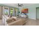 Bright living room with a comfortable couch, neutral decor, and a large television for entertainment at 7618 Oakmoss Loop, Davenport, FL 33837