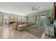 Spacious living room features tile floors, a modern ceiling fan, and large windows with natural light at 7618 Oakmoss Loop, Davenport, FL 33837