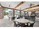 Spacious outdoor bar area with stone countertops, ceiling fans, and ample seating at 7618 Oakmoss Loop, Davenport, FL 33837