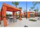 Outdoor patio features a seating area with comfortable chairs and orange canopies for relaxation at 7618 Oakmoss Loop, Davenport, FL 33837
