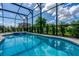 Inviting in-ground pool and spa surrounded by a screened enclosure for relaxing and entertaining outdoors at 7618 Oakmoss Loop, Davenport, FL 33837