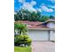 Two car garage with a brick driveway and beautiful green landscaping at 7629 Chapelhill Dr, Orlando, FL 32819