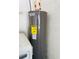 A gray Rheem water heater with an energy guide is positioned next to a white washing machine in the house at 7629 Chapelhill Dr, Orlando, FL 32819