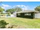 Expansive backyard featuring a lush lawn, privacy fence, pool, and charming ivy-covered home at 901 Golfside Dr, Winter Park, FL 32792