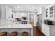 Bright, modern kitchen with white cabinets, stainless steel appliances, and a marble countertop breakfast bar at 901 Golfside Dr, Winter Park, FL 32792