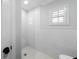 Bright shower area with white subway tiles, a window with plantation shutters, and clean lines at 901 Golfside Dr, Winter Park, FL 32792