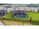 An aerial view of the home with a screened-in pool and well-manicured lawn in a fenced yard at 905 Ocean Course Ave, Davenport, FL 33896
