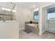 Bright bathroom featuring a soaking tub, separate shower and access to the backyard patio at 905 Ocean Course Ave, Davenport, FL 33896