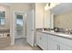 Bright bathroom with double vanity, modern fixtures, and a door leading to the outdoors at 905 Ocean Course Ave, Davenport, FL 33896