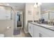 Bathroom with double sinks, a glass-enclosed shower, and a view into an adjacent bedroom at 905 Ocean Course Ave, Davenport, FL 33896