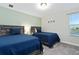 Comfortable bedroom with twin beds, neutral carpet and walls, and lots of natural light at 905 Ocean Course Ave, Davenport, FL 33896