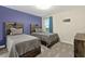 Charming bedroom featuring two twin beds with wooden headboards against a blue accent wall at 905 Ocean Course Ave, Davenport, FL 33896