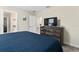 Cozy bedroom featuring a plush blue quilt, TV set on a wooden dresser, and access to a bathroom at 905 Ocean Course Ave, Davenport, FL 33896