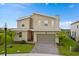 Charming two-story home featuring modern architecture, a stone chimney, and a red front door at 905 Ocean Course Ave, Davenport, FL 33896