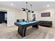 Open game room featuring a pool table, contemporary lighting, and a black leather sofa at 905 Ocean Course Ave, Davenport, FL 33896