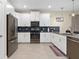 Modern kitchen featuring white cabinets, stainless steel appliances, and a sleek, stylish design at 905 Ocean Course Ave, Davenport, FL 33896