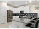 Well-lit kitchen with white cabinets, stainless steel appliances, a gray countertop, and bar stool seating at 905 Ocean Course Ave, Davenport, FL 33896