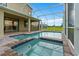Relaxing outdoor pool and spa area within a screened lanai, offering views of the backyard at 905 Ocean Course Ave, Davenport, FL 33896