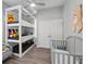 A bedroom with a triple bunk bed, a crib, and hardwood floors at 931 Croton Rd, Celebration, FL 34747