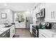 Modern kitchen with stainless steel appliances, white cabinets, and a large sink at 931 Croton Rd, Celebration, FL 34747