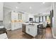 Open concept kitchen and living room with white cabinets, hardwood floors, and barstool seating at 931 Croton Rd, Celebration, FL 34747