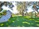 Community playground featuring climbing wall, swings, and play structures on a green lawn under shady trees at 931 Croton Rd, Celebration, FL 34747