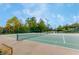Well-maintained tennis court with a bench, net, and trees in the background, offering a serene setting at 931 Croton Rd, Celebration, FL 34747