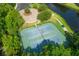 Aerial view of tennis courts nestled in lush greenery and surrounded by a walking trail and pond at 931 Croton Rd, Celebration, FL 34747