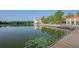 Beautiful waterfront view with a wooden walkway, lush greenery, and the reflection of a building in the water at 931 Croton Rd, Celebration, FL 34747