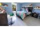 Blue bedroom featuring a bed with colorful comforter and decorative shelving at 1060 Elkcam Blvd, Deltona, FL 32725
