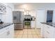 Well-lit kitchen with stainless steel appliances, white cabinets, and a tile floor at 1060 Elkcam Blvd, Deltona, FL 32725