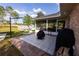 The backyard features a patio with outdoor cooking facilities, a grill, and a brick exterior wall at 1060 Elkcam Blvd, Deltona, FL 32725