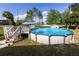 An above-ground pool with a deck and steps offers a private backyard oasis for relaxation and recreation at 1060 Elkcam Blvd, Deltona, FL 32725
