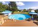 A backyard pool with attached deck, ladder, and shade umbrellas offers backyard fun and recreation at 1060 Elkcam Blvd, Deltona, FL 32725