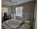 Bedroom with two windows, neutral walls, a ceiling fan, and a bed with patterned bedding at 1118 Arrowsmith Ave, Orlando, FL 32809