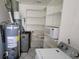 Utility room featuring the water heater, laundry equipment, and pantry storage at 1118 Arrowsmith Ave, Orlando, FL 32809