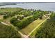 Expansive property with lush landscaping, and partial view of lake, enclosed with white fencing at 11200 Lane Park Rd, Tavares, FL 32778