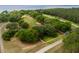 Aerial view of a sprawling property with lake access, defined by a red outline and white perimeter fencing at 11200 Lane Park Rd, Tavares, FL 32778