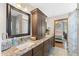 Bathroom with granite counters, dual sinks, and a view of the bedroom at 11200 Lane Park Rd, Tavares, FL 32778