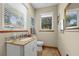 Cozy powder room with granite vanity, toilet, and ample natural light at 11200 Lane Park Rd, Tavares, FL 32778