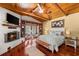 Comfortable bedroom with wood ceilings, fireplace, built-in shelving, and hardwood floors at 11200 Lane Park Rd, Tavares, FL 32778