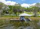 View of private boat dock with lift on lake featuring boat and lakeside home at 11200 Lane Park Rd, Tavares, FL 32778