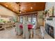 Charming dining area featuring a red tablecloth, fireplace, wood ceilings, and screened lanai access at 11200 Lane Park Rd, Tavares, FL 32778